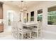 Bright dining area features a large table, white chairs, pendant lighting, and views of the backyard at 150 Portofino Blvd, New Smyrna Beach, FL 32168