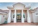 Welcoming front entrance with brick detail, supported columns, and double doors, enhanced by lush plants at 150 Portofino Blvd, New Smyrna Beach, FL 32168
