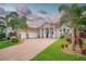 Beautiful home featuring manicured landscaping, tile roof, brick drive, and a three-car garage at 150 Portofino Blvd, New Smyrna Beach, FL 32168