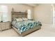 Neutral main bedroom featuring a king-sized bed, a patterned duvet, and side tables with lamps at 150 Portofino Blvd, New Smyrna Beach, FL 32168
