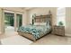 Main bedroom features a king-sized bed, a sliding glass door to the patio, and neutral decor at 150 Portofino Blvd, New Smyrna Beach, FL 32168