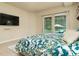 Spacious main bedroom with a king-size bed, TV, and sliding glass doors leading to the outdoor pool area at 150 Portofino Blvd, New Smyrna Beach, FL 32168