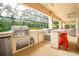 Gourmet outdoor kitchen featuring stainless steel appliances, a grill, and a convenient bar area at 150 Portofino Blvd, New Smyrna Beach, FL 32168