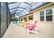 Covered outdoor seating area with screened-in patio and multiple colorful chairs with serene views at 150 Portofino Blvd, New Smyrna Beach, FL 32168