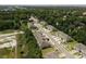 Aerial view of townhome community featuring well-maintained lawns, landscaping, and roadways surrounded by trees at 1615 Primo Ct, Holly Hill, FL 32117