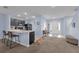 Open-concept living space featuring a breakfast bar, neutral carpet, and smooth walls, perfect for comfortable living and entertaining at 1615 Primo Ct, Holly Hill, FL 32117