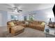 Spacious living room with a large sectional sofa, ceiling fan, and access to outdoor space at 1615 Primo Ct, Holly Hill, FL 32117