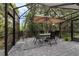 A screened patio features a dining table, chairs, umbrella, and tiled flooring, perfect for outdoor entertaining at 1615 Primo Ct, Holly Hill, FL 32117