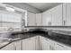 Updated kitchen featuring granite countertops, white cabinets, and stainless steel dishwasher at 167 N Hill Ave # 60, Deland, FL 32724