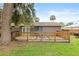 Wide-angle view of a backyard with a wooden fence, mature trees and the home's back patio at 1723 Needle Palm Dr, Edgewater, FL 32132