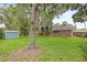 Large backyard features a shed, a deck, mature trees, and a privacy fence, enhancing the outdoor living space at 1723 Needle Palm Dr, Edgewater, FL 32132