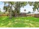 Spacious backyard with a wooden deck, shade trees, and a privacy fence, ideal for outdoor entertaining at 1723 Needle Palm Dr, Edgewater, FL 32132