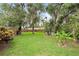 Expansive backyard featuring mature trees, lush lawn, and a privacy fence, perfect for outdoor enjoyment at 1723 Needle Palm Dr, Edgewater, FL 32132