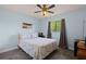 A serene bedroom with a ceiling fan, a comfortable queen-size bed, and a view of the outdoors at 1723 Needle Palm Dr, Edgewater, FL 32132