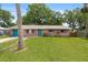 Lovely single-story home with a bright blue front door and large, lush front yard at 1723 Needle Palm Dr, Edgewater, FL 32132