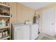 Functional laundry room with modern washer, dryer, shelving, and storage space, providing convenience at 1723 Needle Palm Dr, Edgewater, FL 32132
