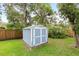 Backyard storage shed with freshly painted blue exterior and white trim, nestled in the green lawn at 1723 Needle Palm Dr, Edgewater, FL 32132