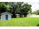 View of backyard with lawn, sheds, and trees at 1920 Travelers Palm Dr, Edgewater, FL 32141