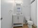 This bathroom features a single sink vanity with a mirror and a toilet with a shower and a light wood floor at 1920 Travelers Palm Dr, Edgewater, FL 32141