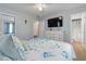 Bright bedroom featuring a bed, TV, dresser, ceiling fan and two entry doors, creating a versatile living space at 1920 Travelers Palm Dr, Edgewater, FL 32141