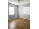 This bedroom has a ceiling fan, two windows, and wood flooring at 1920 Travelers Palm Dr, Edgewater, FL 32141