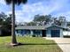 Charming single-story home with a well-manicured lawn, palm tree, and a one-car garage in a residential neighborhood at 1920 Travelers Palm Dr, Edgewater, FL 32141