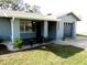 Well-maintained home exterior with a cozy front porch and nicely landscaped front yard at 1920 Travelers Palm Dr, Edgewater, FL 32141