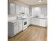 Functional kitchen with white cabinetry, modern appliances, stone countertops, and wood-look vinyl flooring at 1920 Travelers Palm Dr, Edgewater, FL 32141