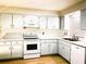 Clean kitchen featuring modern appliances, plenty of cabinet space, stone counters, and updated wood-look floors at 1920 Travelers Palm Dr, Edgewater, FL 32141