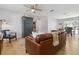 Bright living room with ceiling fan, laminate flooring, and comfortable leather seating at 1920 Travelers Palm Dr, Edgewater, FL 32141