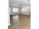 Bright, open living room with new vinyl floors, a ceiling fan, a front door, and a large window for natural light at 1920 Travelers Palm Dr, Edgewater, FL 32141