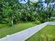 A well maintained backyard surrounded by trees and a white fence creates a private and serene outdoor space at 1941 Spruce Creek Lndg, Port Orange, FL 32128