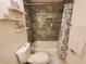 Cozy bathroom featuring a tub with tile surround, floating shelves, and decorative shower curtain at 1941 Spruce Creek Lndg, Port Orange, FL 32128