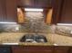 Close up of sink, granite counters, tile backsplash, and stainless faucet at 1941 Spruce Creek Lndg, Port Orange, FL 32128