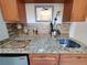 Close-up of a kitchenette featuring a stainless steel sink, cabinetry, and granite countertops at 1941 Spruce Creek Lndg, Port Orange, FL 32128