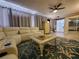 Inviting living room features an L shaped sofa, stylish rug and lots of natural light at 1941 Spruce Creek Lndg, Port Orange, FL 32128
