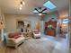 Inviting living room features a wet bar, a ceiling fan, skylights, and two comfortable armchairs at 1941 Spruce Creek Lndg, Port Orange, FL 32128