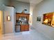 Hallway featuring a wet bar with a granite countertop, small refrigerator, and ample storage at 1941 Spruce Creek Lndg, Port Orange, FL 32128