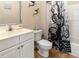 Bathroom with white vanity, toilet, and shower with unique ocean themed shower curtain at 1983 Turnbull Lakes Dr, New Smyrna Beach, FL 32168