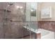 Bathroom featuring tub and glass shower with stone surround and a built in toiletry shelf at 1983 Turnbull Lakes Dr, New Smyrna Beach, FL 32168