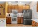 Well-lit kitchen featuring stainless steel appliances, wooden cabinets, and granite countertops at 1983 Turnbull Lakes Dr, New Smyrna Beach, FL 32168