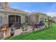 Rear patio with an outdoor seating area, a BBQ, and lush green grass at 1983 Turnbull Lakes Dr, New Smyrna Beach, FL 32168