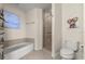 Bright bathroom with a bathtub, glass-enclosed shower, and toilet accented by unique wall art at 2 Oceans West Blvd # 702, Daytona Beach, FL 32118