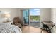 This bedroom includes a seating area, balcony with furniture, and a desk at 2 Oceans West Blvd # 702, Daytona Beach, FL 32118