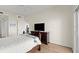 This is an airy bedroom with an open door to a hallway and dark wood dresser at 2 Oceans West Blvd # 702, Daytona Beach, FL 32118