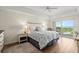 Bright bedroom with ceiling fan and a balcony overlooking water and golf course at 2 Oceans West Blvd # 702, Daytona Beach, FL 32118