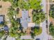 Aerial view of a landscaped property with a home, driveway, shed, and surrounding trees at 200 W Washington Ave, Deland, FL 32720