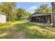 Lush backyard showcasing a screened patio and storage shed at 200 W Washington Ave, Deland, FL 32720