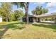 Expansive backyard featuring a screened patio, a carport and mature trees at 200 W Washington Ave, Deland, FL 32720