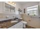 The bathroom features a granite countertop, classic white tiles, and a window at 200 W Washington Ave, Deland, FL 32720